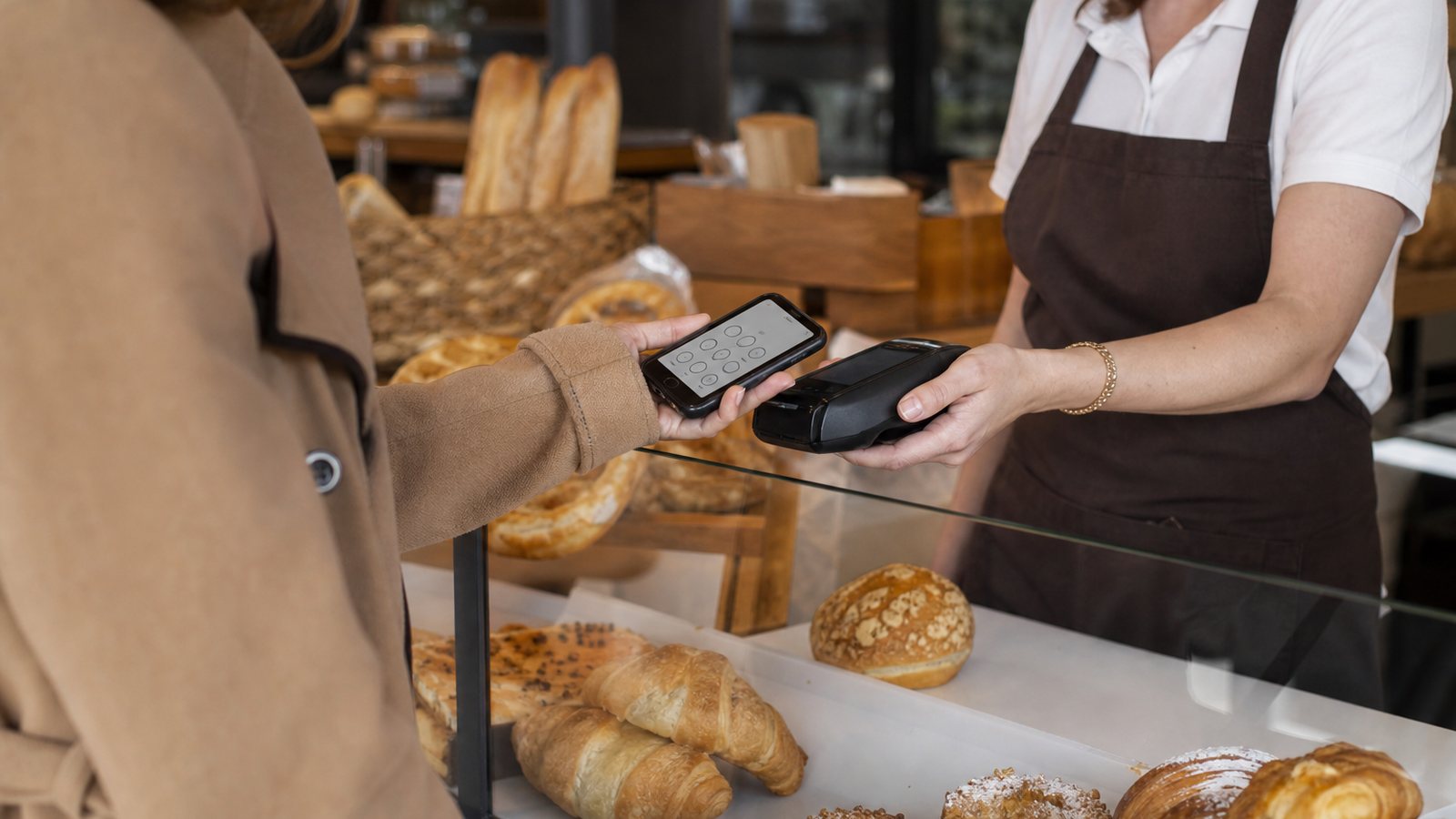 Commerçante proposant la carte de fidélité pendant l'encaissement à un client au comptoir